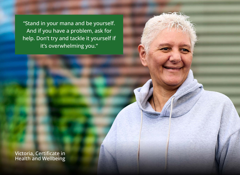 Victoria stands at her workplace in front of a colourful mural, smiling. Quote says “Stand in your mana and be yourself. And if you have a problem, ask for help. Don't try and tackle it yourself if it's overwhelming you.” Victoria, Certificate in Health a