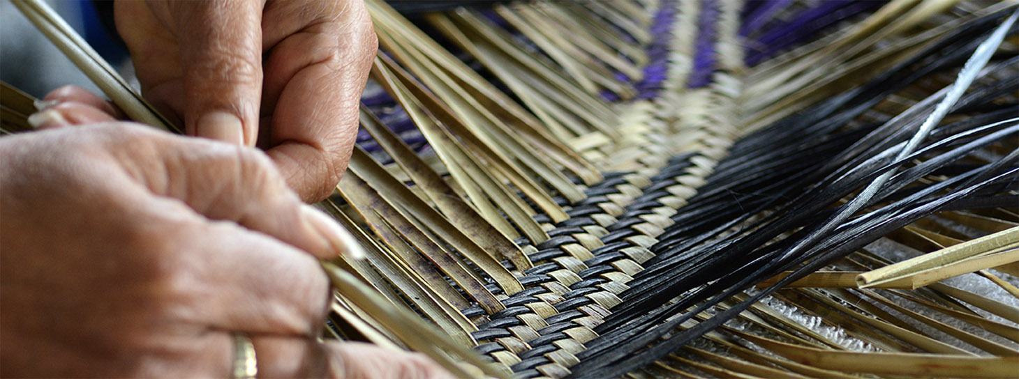 Female hands weaving coloured flax