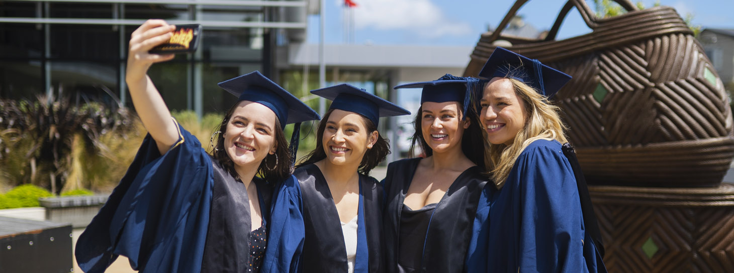 Four women in gowns after graduation